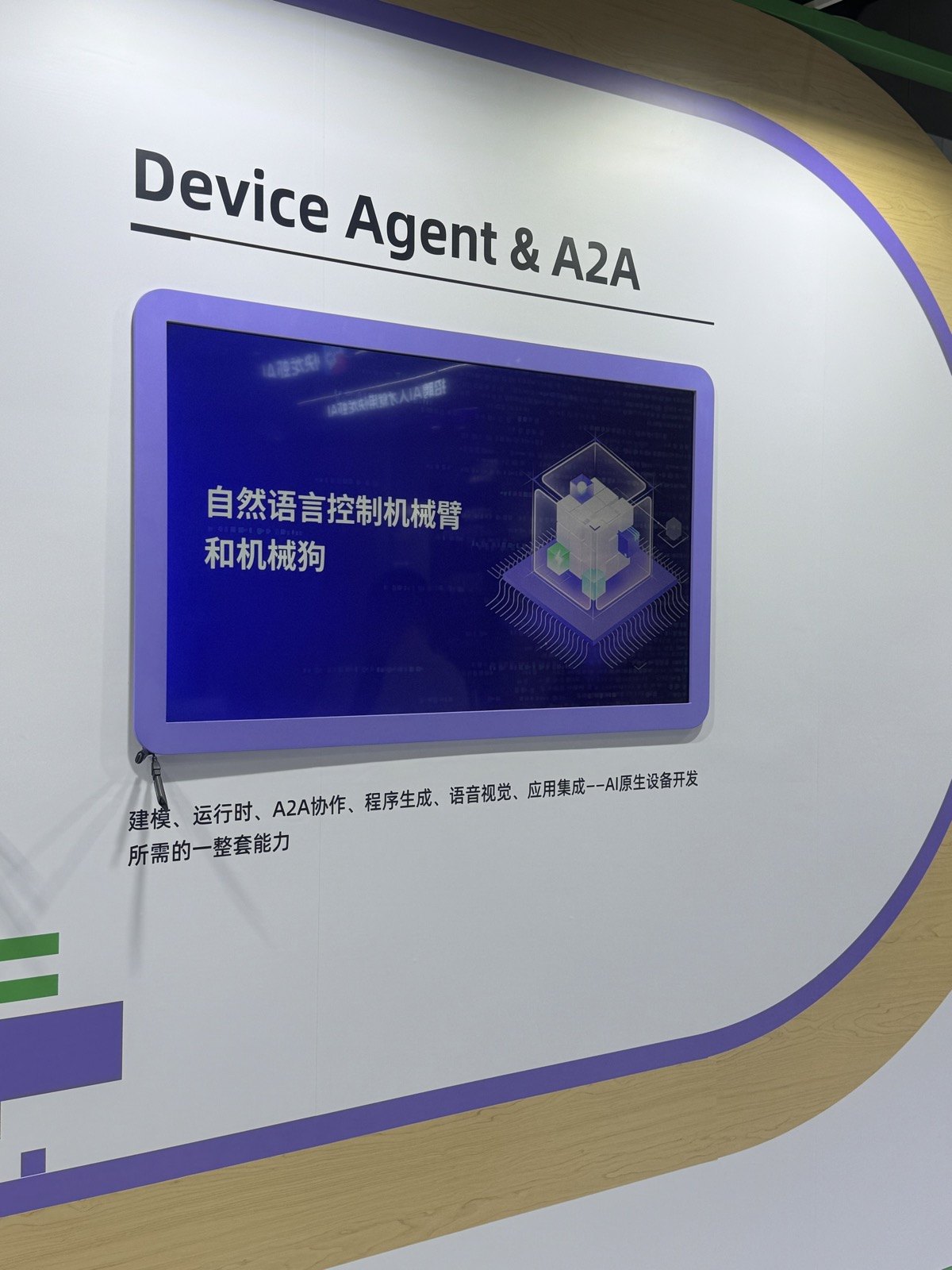 Device Agent & A2Aの壁面展示。画面に「自然语言控制机械臂和机械狗」